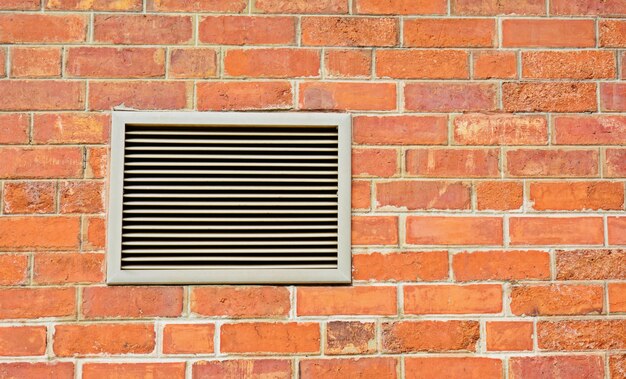 Muro di mattoni e ventilatore arancio - primo piano