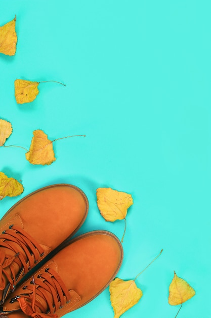 Orange brown mens autumn boots on mint pastel . Top view, copyspace.