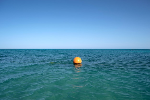 바다 표면 파도에 떠 있는 주황색 부표 인간의 생명 안전 개념