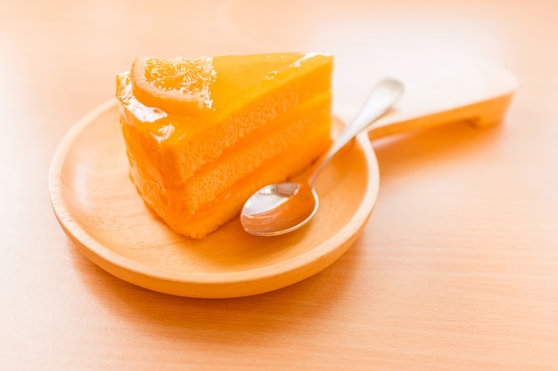 Orange cake sweet dessert in wooden plate on wooden table