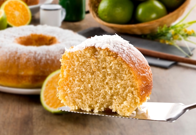 Orange cake on the table with fruits and juice.