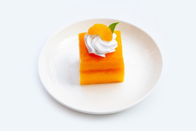 Orange cake in white plate on white background.