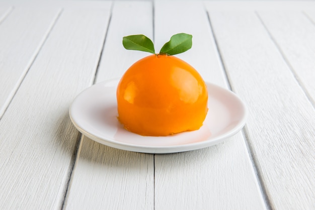 Orange cake on white wooden table