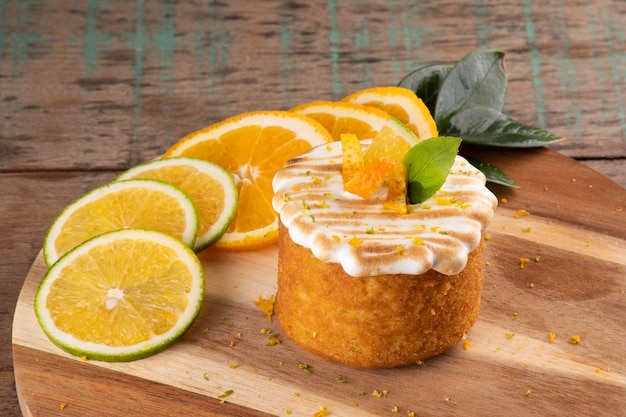 写真 オレンジのスライスとビストロのクローズ アップの素朴な木のテーブルにトーストした白いクリームをトッピングしたオレンジ ケーキ