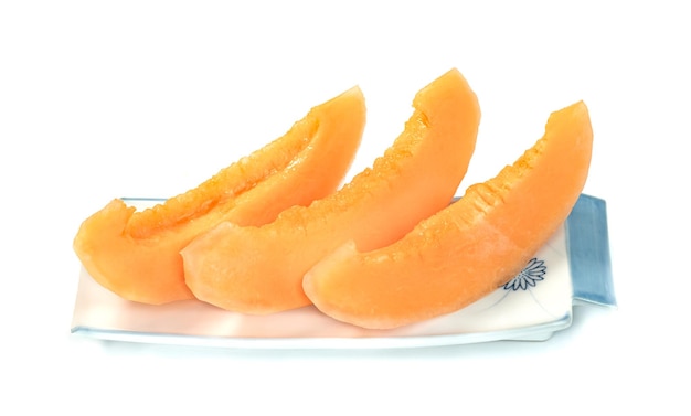 Photo orange cantaloupe melon fruit sliced on dish isolated on white background