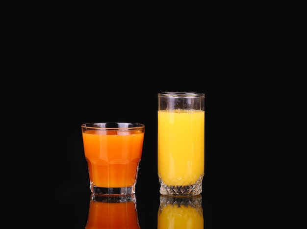 Orange and carrot juice on a black