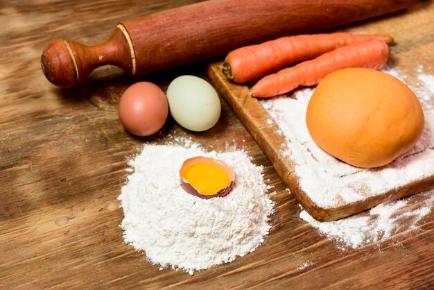 Orange carrot noodle dough bun with ingredients on the table