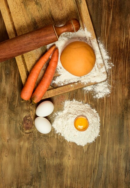 Foto panino di pasta di carota arancione con gli ingredienti sul tavolo