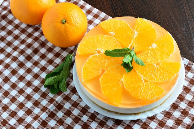 orange cheesecake with mint on the brown tablecloth