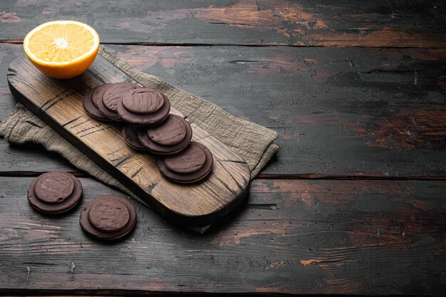 Orange Chocolate coated biscuit cakes set, on old dark  wooden table background, with copy space for text