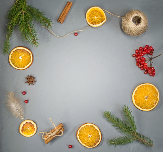 Orange, cinnamon, feather and a sprig of spruce, flatly, copy space.