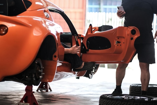 検査のためのワークショップでオレンジ色のクラシックスポーツカー