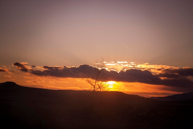 Orange clouds over the mountain at sunset