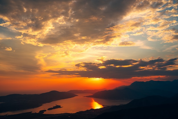 ロブチェン山からの湾の景色に沈む夕日の光線のオレンジ色の雲