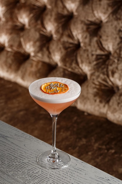 Orange Clover Club Cocktail in Coupe glas met laag schuim en sinaasappelchips Garneer geïsoleerd op donkere achtergrond