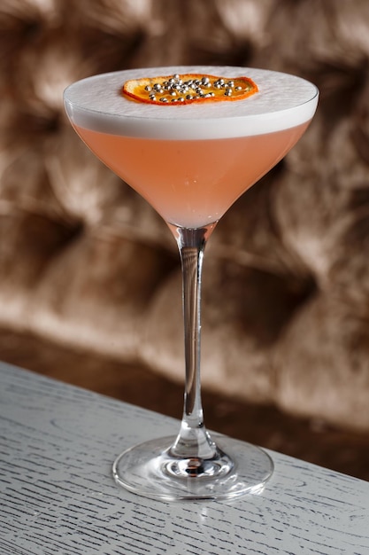 Orange Clover Club Cocktail in Coupe glas met laag schuim en sinaasappelchips Garneer geïsoleerd op donkere achtergrond