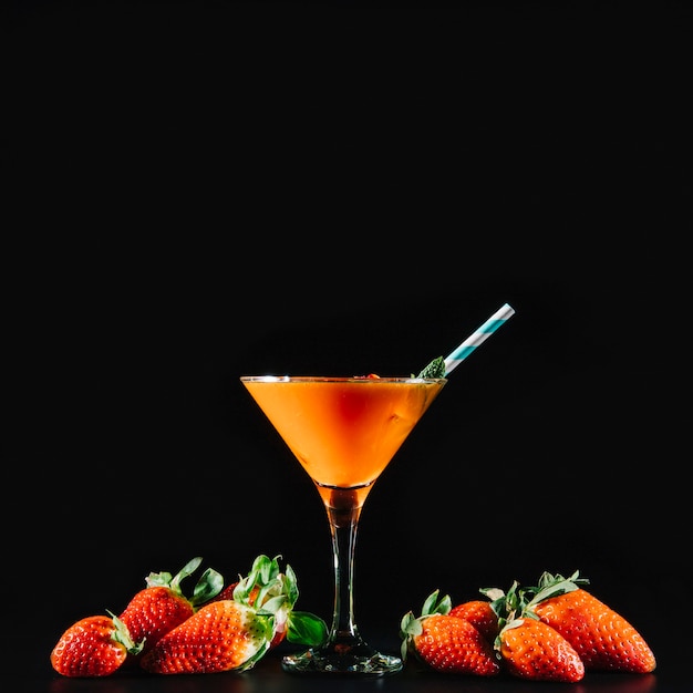 Orange cocktail and exotic fruits on black background