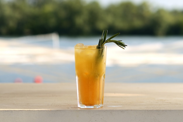 Orange cocktail in a glass. With flower decor