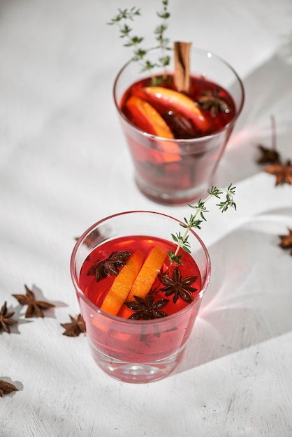 Orange cocktail with rum liquor pear slices and rosemary on white table selective focus