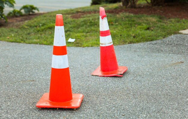 道路上のオレンジ色の建設用コーンは、安全上の注意と建設現場での進行中の作業を象徴しています