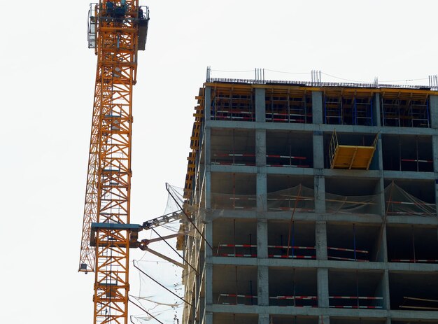 Orange construction crane near building site