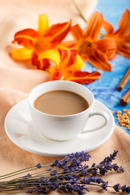 Orange day-lily and lavender flowers and a cup of coffee