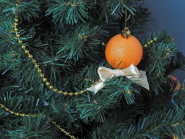 Orange decorative balloon on a Christmas tree. New year and Christmas concept