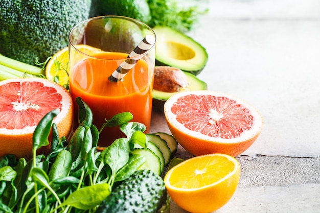 Orange detox smoothie in glass. Ingredients for detox smoothie background.