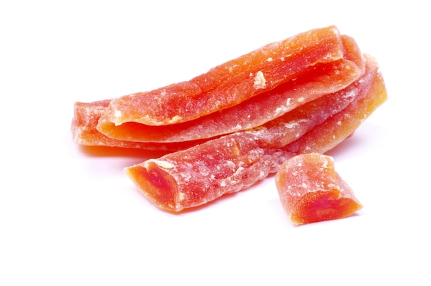 Orange dried papaya slices over white background