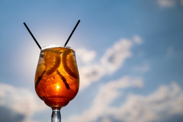 Bevanda all'arancia o cocktail in piedi al tavolino del ristorante o del bar con lo sfondo del mare