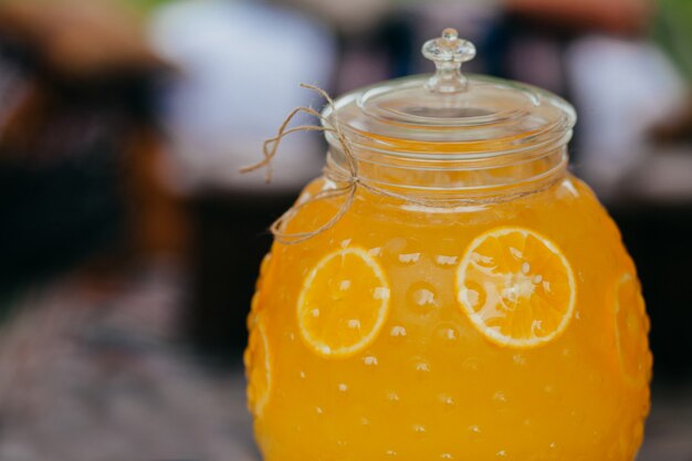 orange drink in glass container. Cold fresh beverage.