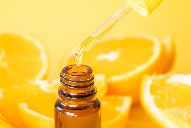 Эфирное масло апельсина на желтом фоне