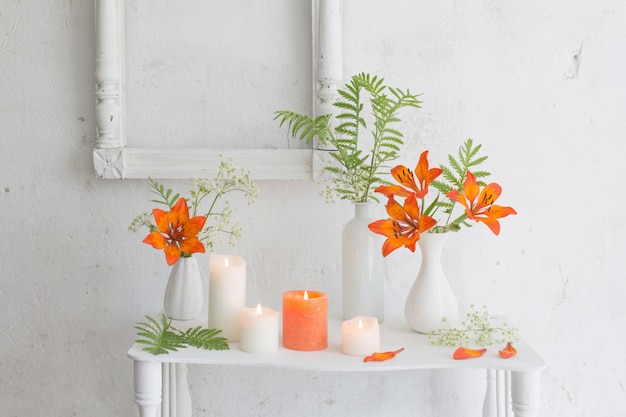 Orange flowers and candles on white background