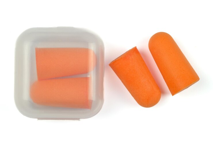 Orange foam soft earplugs on a white background Closeup