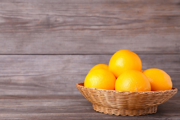 Merce nel carrello arancio della frutta su un fondo grigio