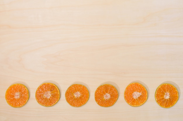 オレンジ色の果物は、木材表面の背景に半分カット。