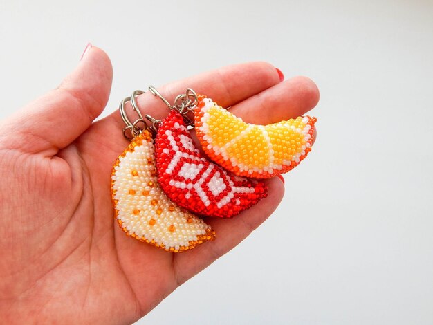 Photo orange fruit keychain lies on a woman's palm