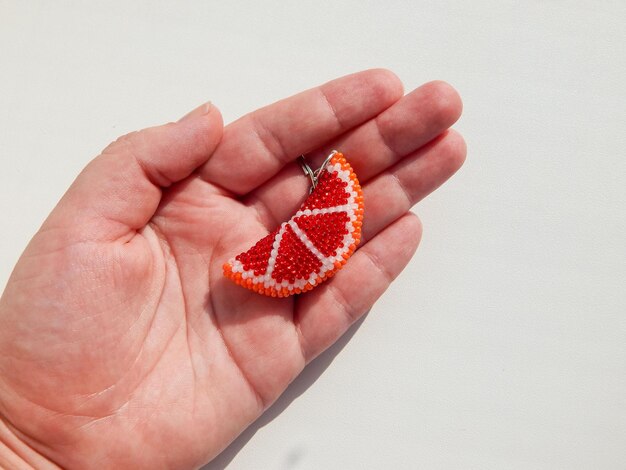 Photo orange fruit keychain lies on a woman's palm