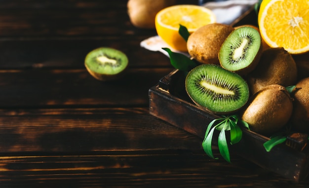 Orange fruit and kiwi fruit in an wooden table