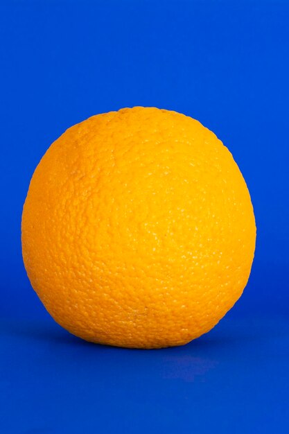 Orange fruit, tangerine, in focus on a blue background