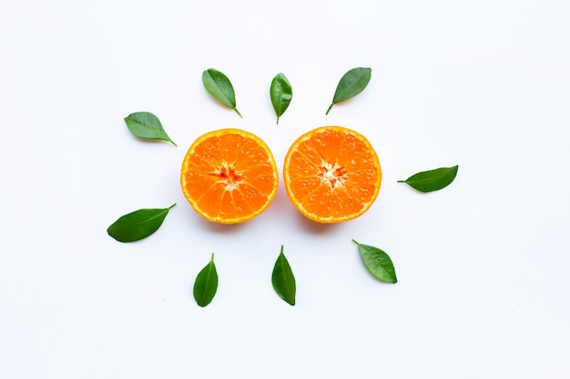 Orange fruits and green leaves on a white background. 