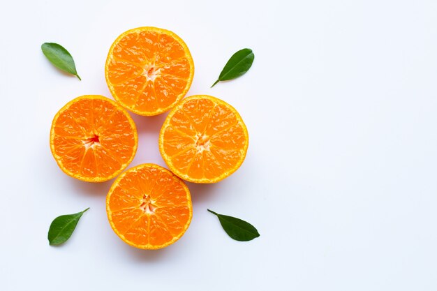 Orange fruits and green leaves on a white background. 