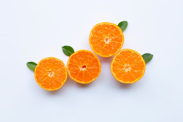 Orange fruits and green leaves on a white background. 