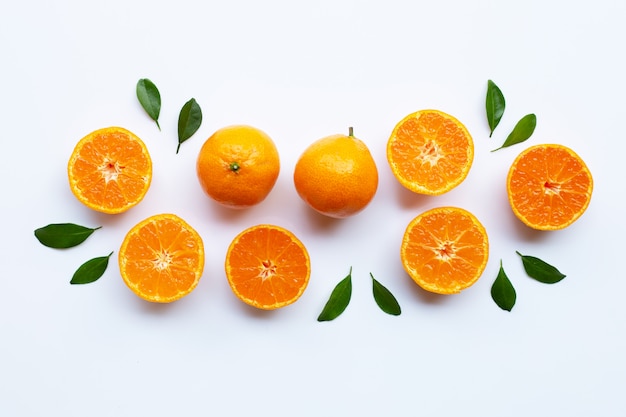 Orange fruits and green leaves on a white background. 