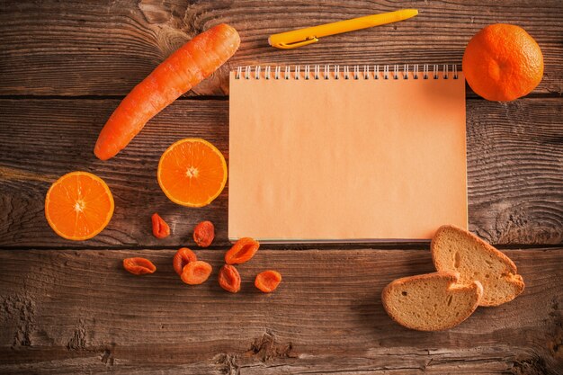 Orange fruits and vegetables on wooden background