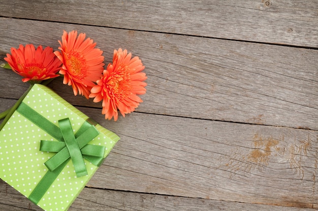 Orange gerbera flowers and gift box