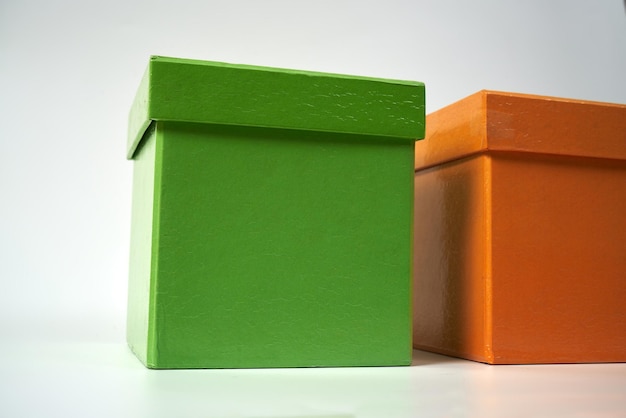 Photo orange and green cardboard gift boxes on a a white isolated background