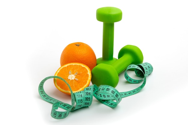 Orange and green dumbbells with a Measuring tape on white