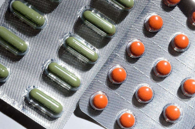 Orange and green pills in a foil blister 