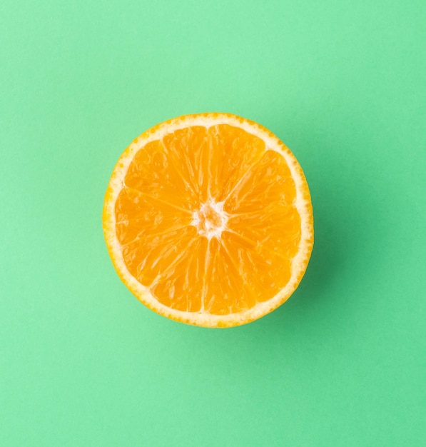 Orange half isolated over green textured background